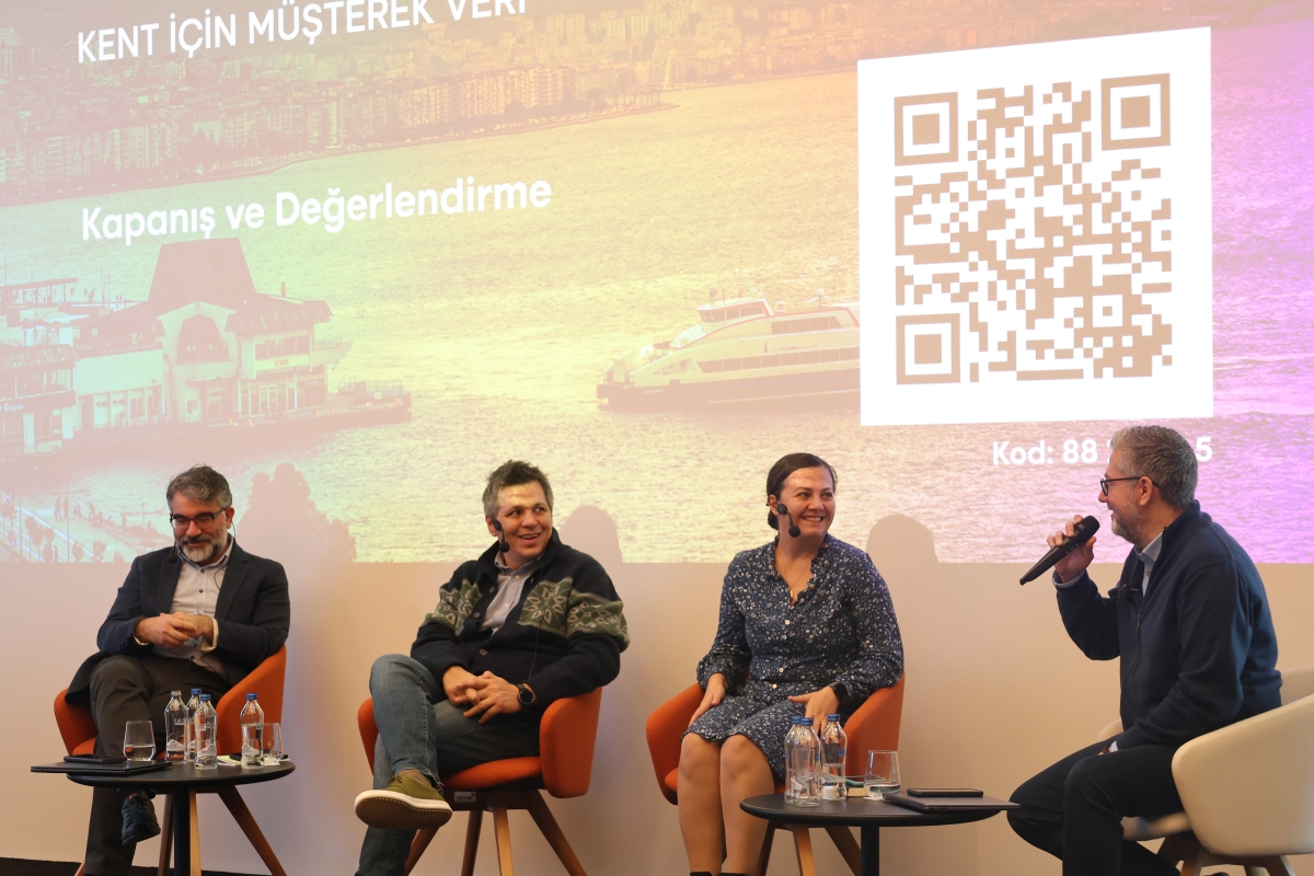 Panelistler ve moderatör sahnede otururken görülüyor
